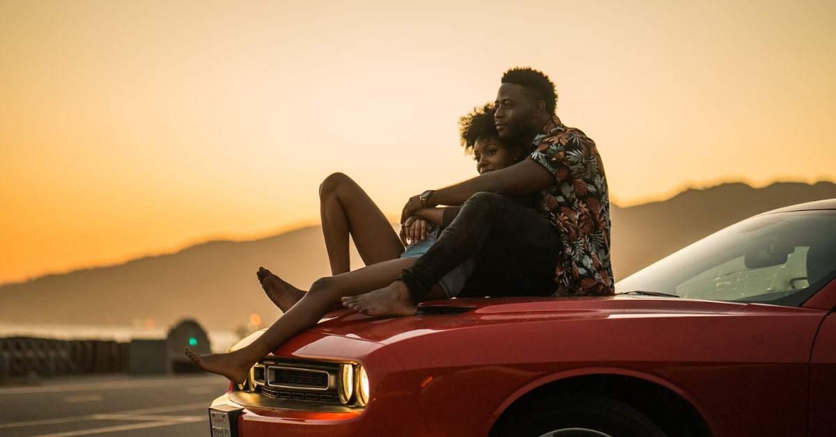 couple on the hood of a car, watching the sunset, couple holding hands, riding into the sunset, lasting love