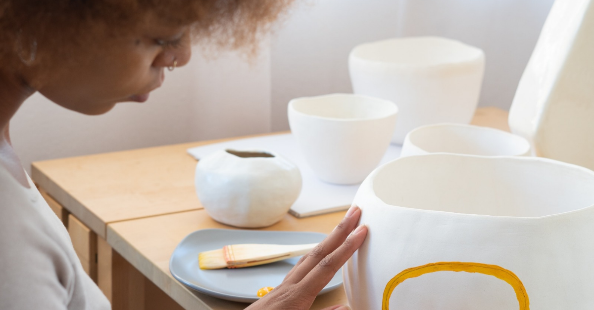 a woman using her creativity to decorate pottery