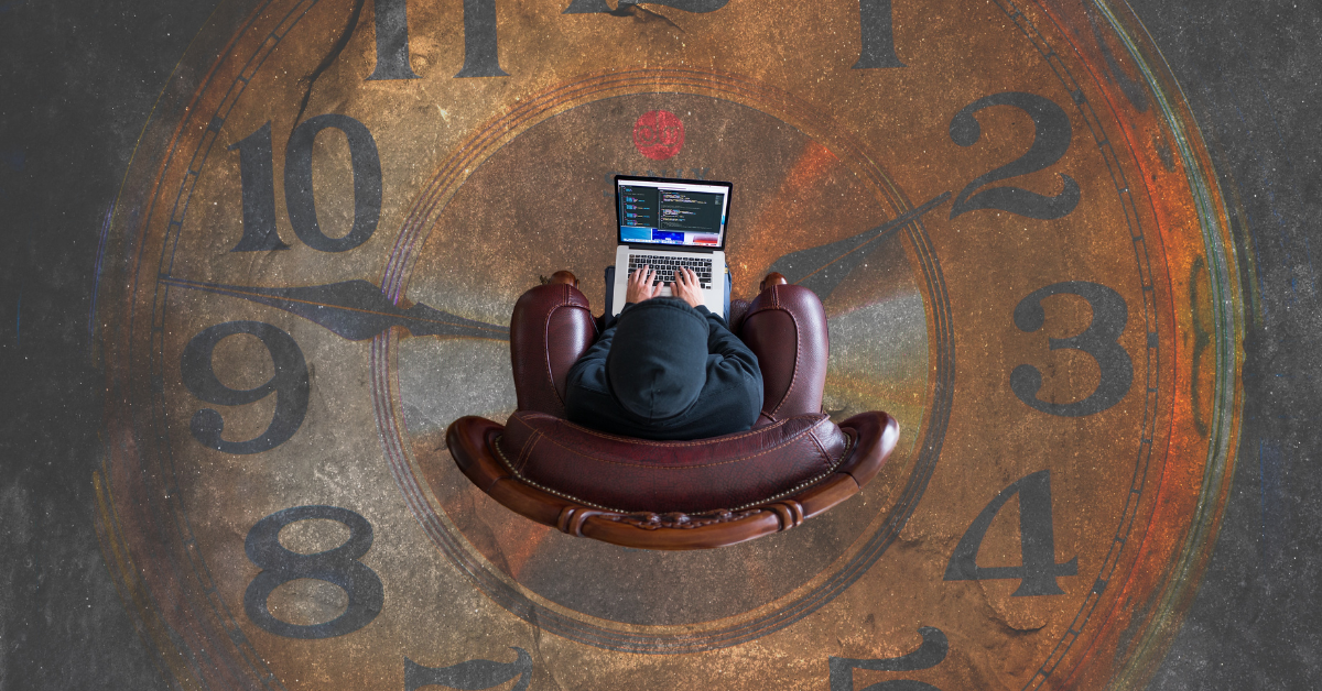 person sitting in an image of a clock, working on a laptop