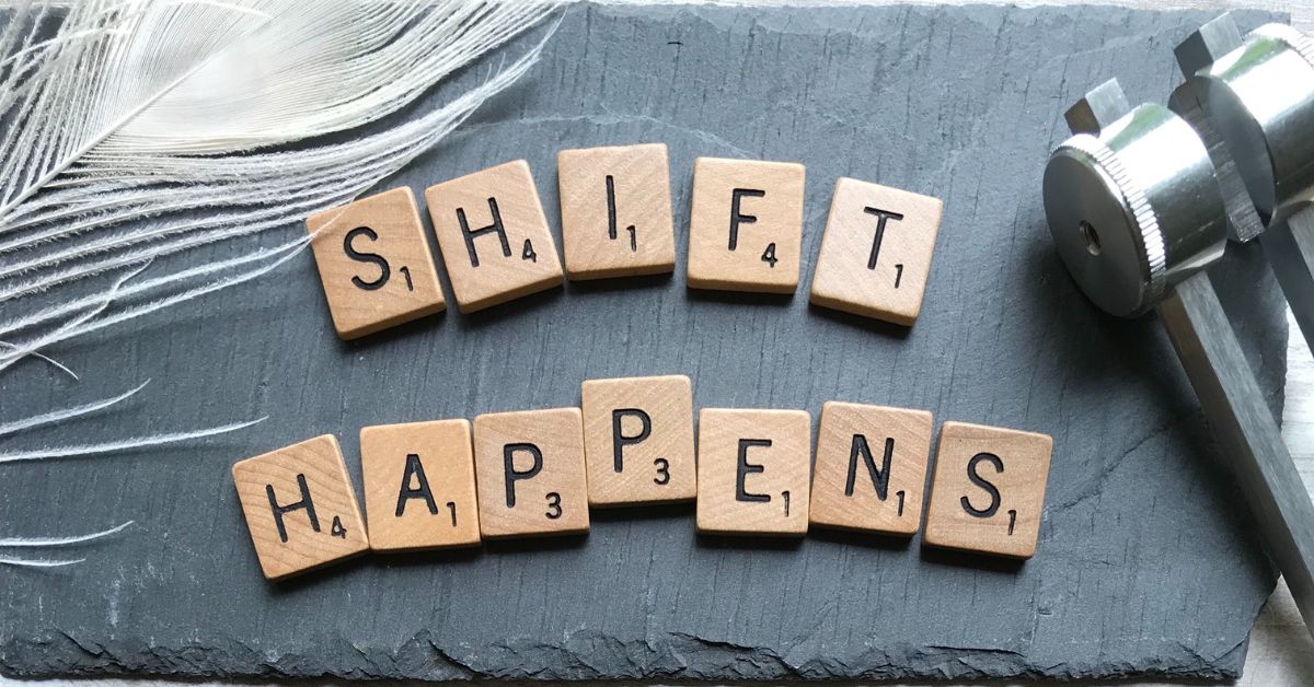 scrabble tiles that spell "shift happens"