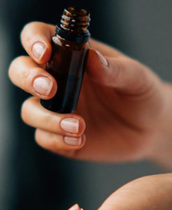 a person holding a bottle of skincare oil serum