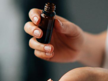 a person holding a bottle of skincare oil serum