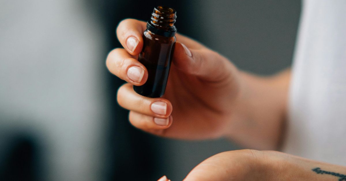 a person holding a bottle of skincare oil serum
